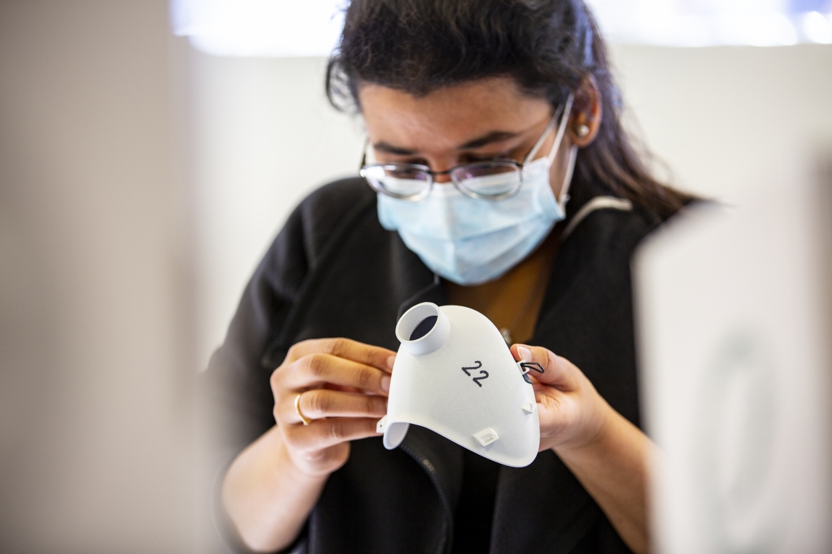 A woman looking at a 3D printed medical mask prototype
