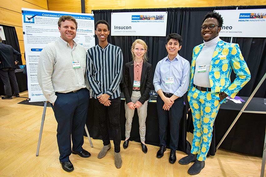 A group shot of five people stand next to each other