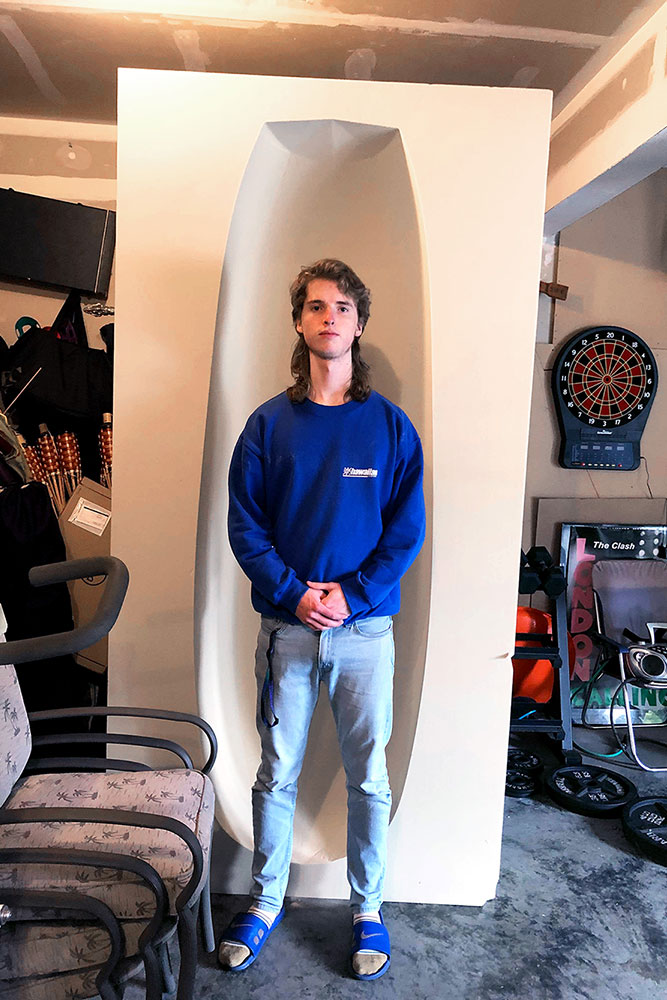 Student standing in front of a pod prototype