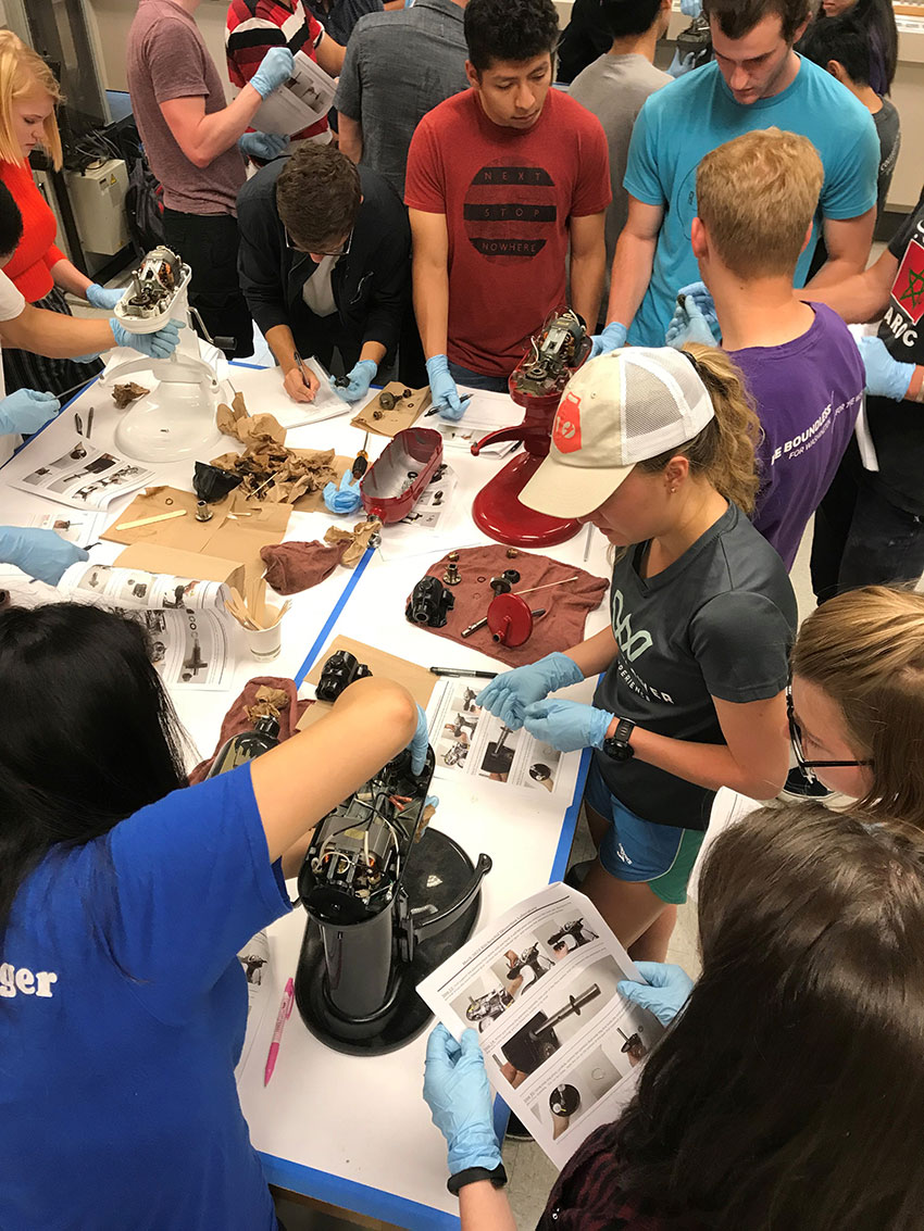 Students disassemble broken Kitchenaid mixers to investigate product design.