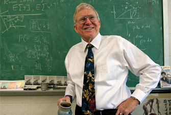 Prof. Ashley Emery in front of chalk board