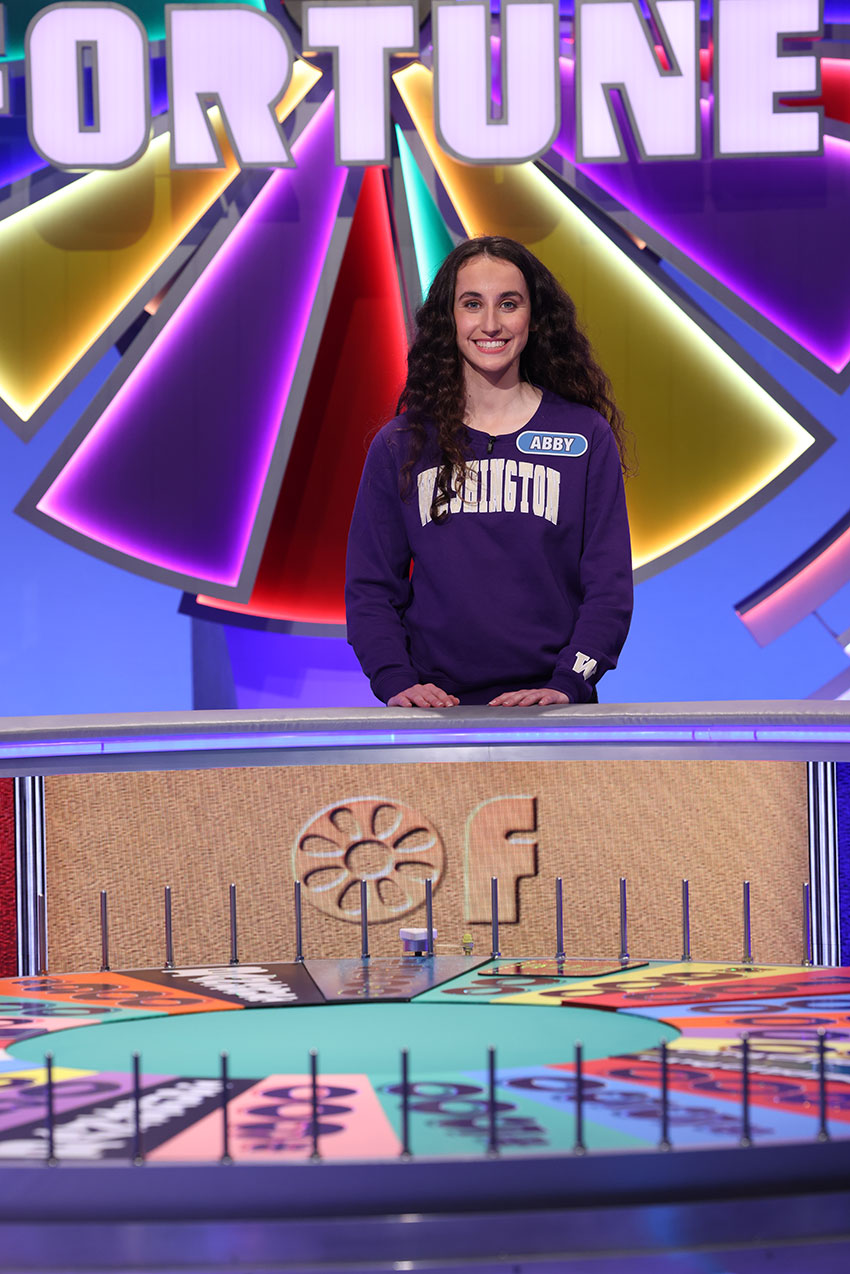 Abby Simcox standing behind the wheel on Wheel of Fortune