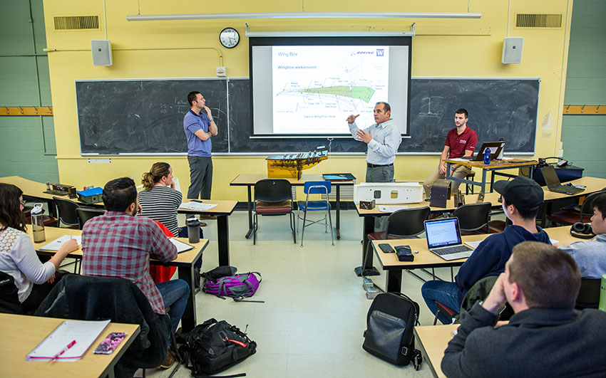 A faculty speaking with a group of students