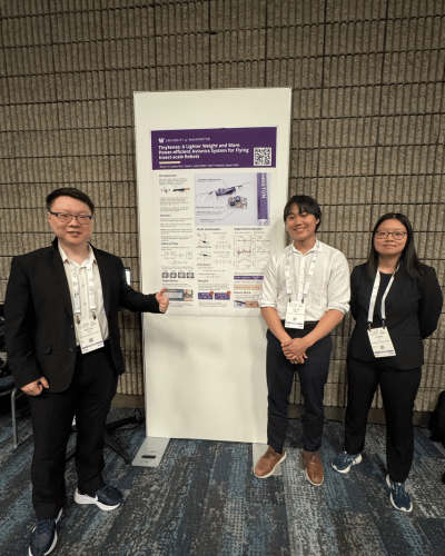 Three students stand next to their poster.