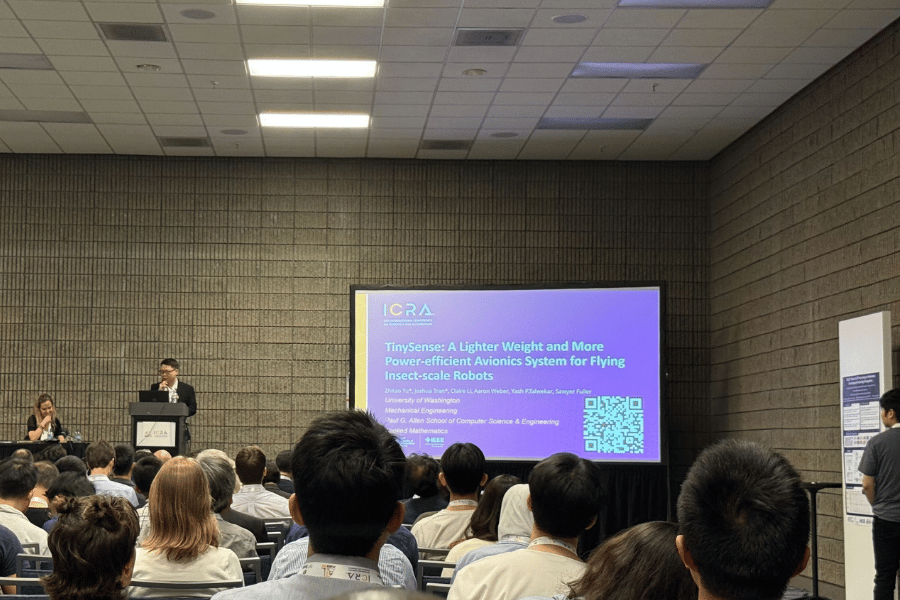 Zhitao Yu stands behind a podium and speaks at a conference. The title page of a presentation about TinySense is shown on a screen.