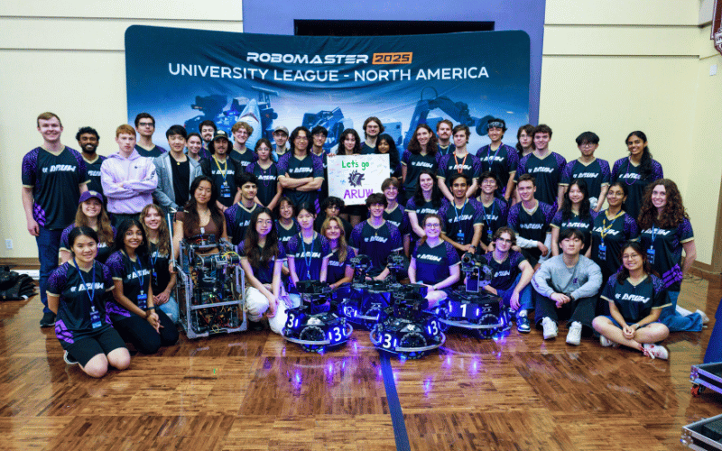 A group of students on the Advanced Robotics at UW team showcasing their robots and wearing matching shirts.