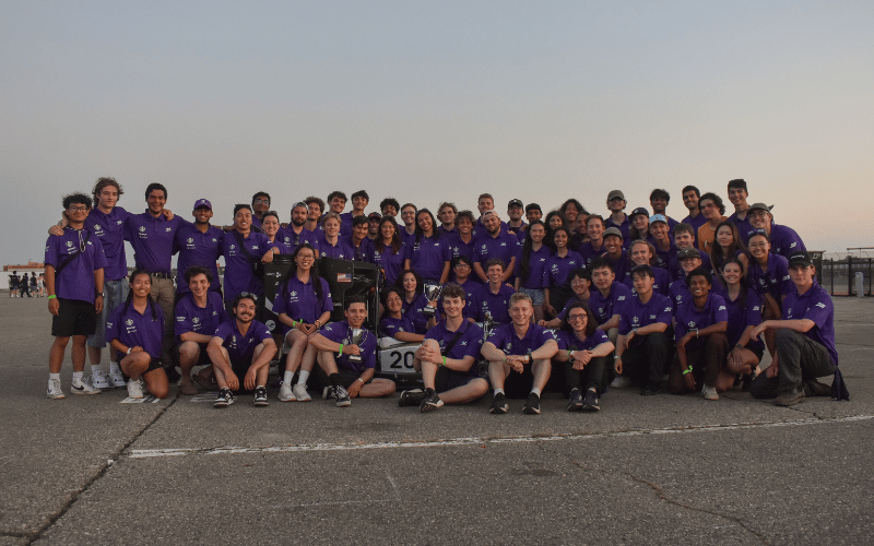 The Formula team around their car, which one person is sitting in, at the Michigan competition.