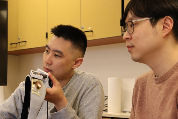 Two researchers examine a sleep mask.
