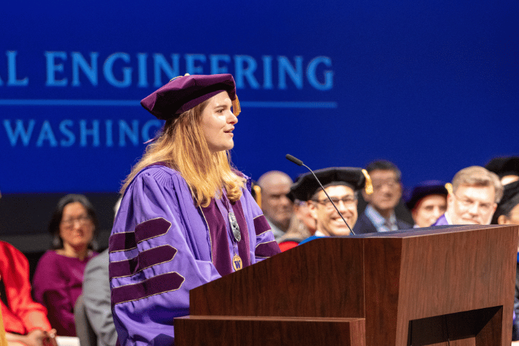 Mia Hoffman speaks into a microphone behind a podium.