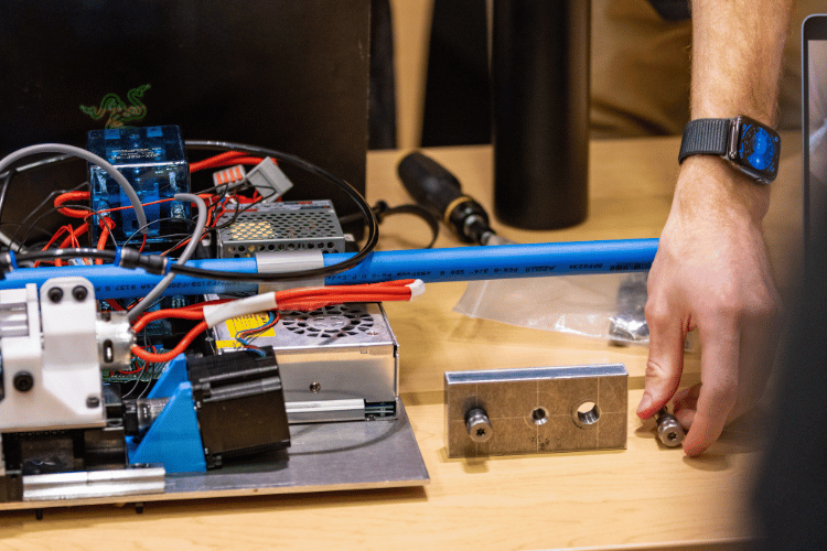 A close-up image of the prototype tool, which has electronic components and wires, alongside fasteners.