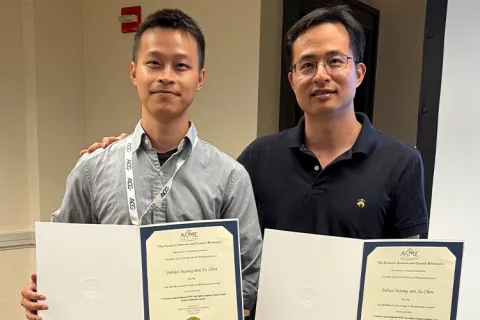 Two individuals holding certificates 