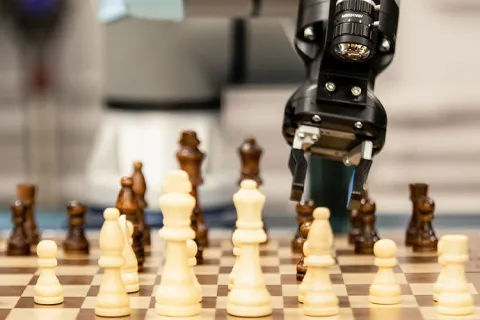 Robot arm playing with chess board