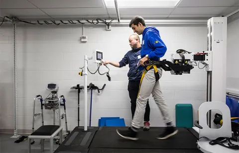 A student walking on treadmill with devices hooked up to him