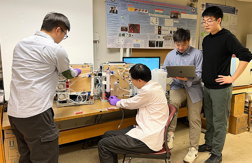 Four researchers gather around a table that holds the AMOR machine, which has various connected tubes.