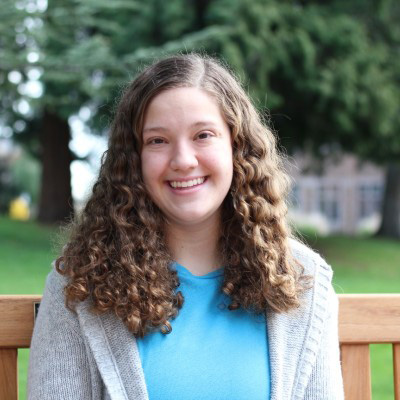 A headshot of Emilee Armstrong with trees in the background