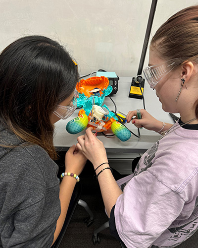 Two students deconstruct a toy at a HuskyADAPT toy adaptation event.