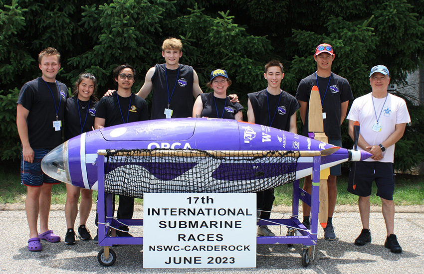 A group of students stand with their human-powered submarine at the 2023 International Submarine Races.