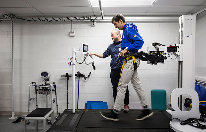 A student walking on treadmill with devices hooked up to him