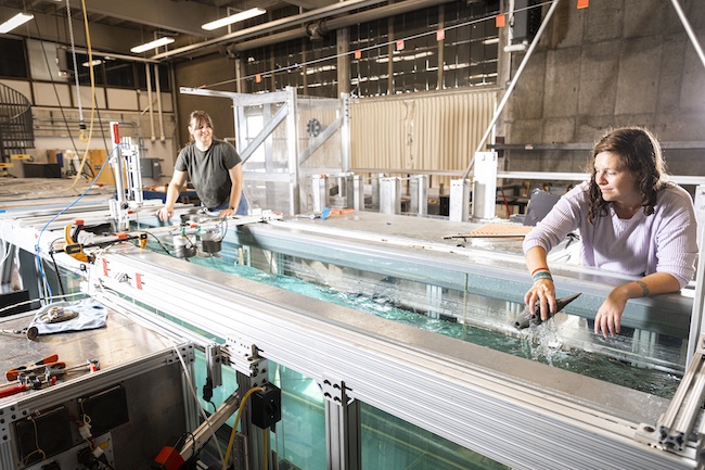 Two women working in a flume at the Harris Hydraulics Lab