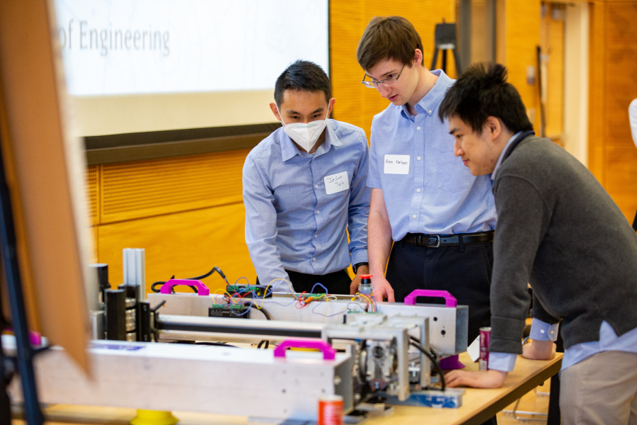 Three students working on a mechanical fixture project together