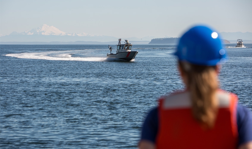 Woman observing boat in the Pacific Ocean