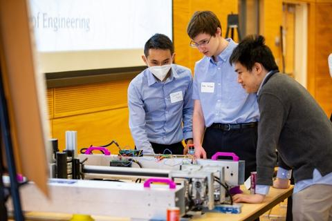 Three students working on a mechanical fixture project together