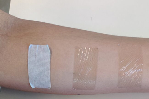 Close up of arm with three pieces of medical tape