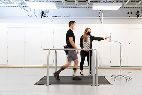 Man walking on a treadmill wearing an exoskeleton device