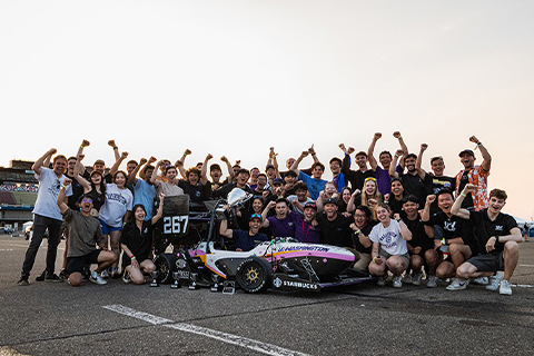 The UW Formula Motorsports team surrounds their race car after the competition.