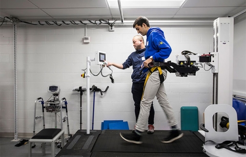 A student walking on treadmill with devices hooked up to him