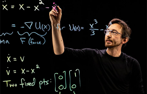 Brunton writing math equations on a lightboard with a marker