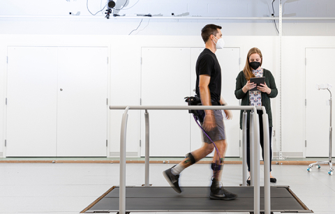 Man walking on a treadmill wearing an exoskeleton device